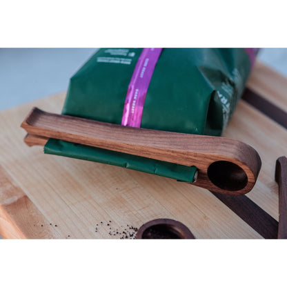 Walnut coffee scoop and bag sealer. This versatile tool allows you to measure the perfect amount of coffee and securely seal the bag for freshness. Crafted from walnut, it adds a touch of elegance to your coffee routine.